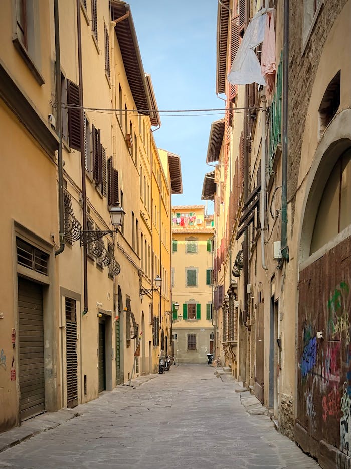 Charming narrow street in Florence, Italy, showcasing historic architecture and vibrant urban life.