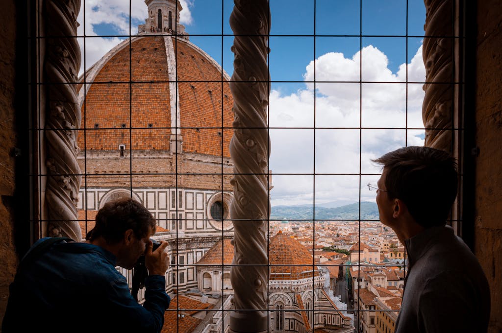 Photographers capturing the iconic Florence Cathedral from a bell tower, offering a spectacular city vista.